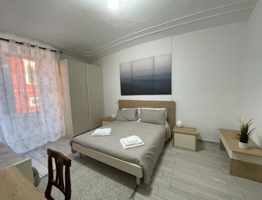 Camera da letto accogliente e luminosa al B&B Melina, con letto matrimoniale, comodini, armadio e decorazioni moderne. Perfetta per un soggiorno rilassante.