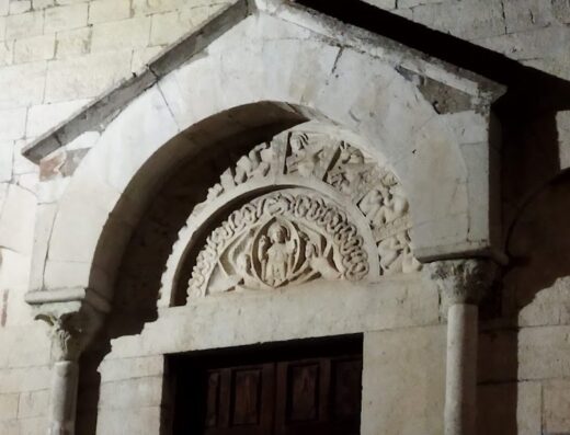 Portale romanico decorato con sculture in pietra presso un B&B a Sagittabondo, ideale per motociclisti in viaggio alla scoperta del territorio.