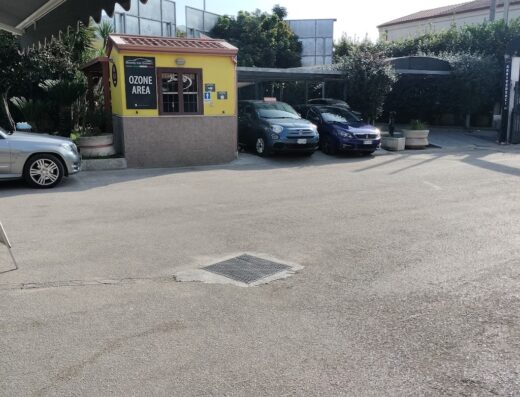 Foto del Beauty Car Center Autolavaggio con auto parcheggiate e area dedicata all'ozono, che offre servizi di pulizia e cura auto.