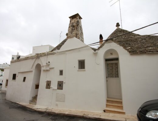 Esterno di un Bed & Breakfast a Piazzetta XI Febbraio, con architettura tipica pugliese e trulli imbiancati a calce.