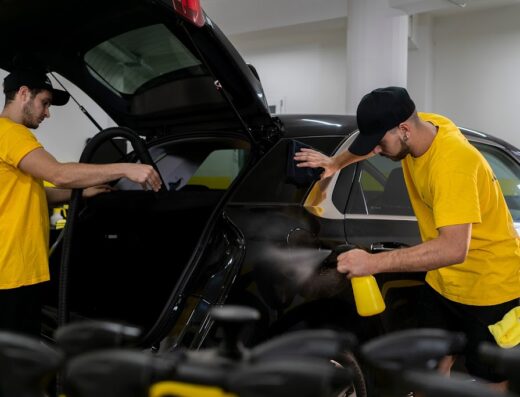 Due addetti di Beewash Benevento puliscono e lucidano una vettura nera, offrendo servizi di autolavaggio e detailing per auto e moto.