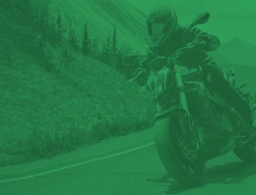 Un motociclista in sella a una moto Benelli percorre una strada di montagna. Accessori e abbigliamento da moto disponibili presso la concessionaria Benelli a Torino.