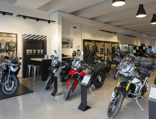 Showroom di Best Motors Italia Srl con esposizione di moto Triumph Tiger 900 Rally Pro e altri modelli. Accessori moto e abbigliamento tecnico disponibili.