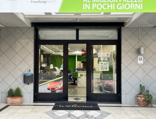 Ingresso di Bi Service Srl Link Motors Amantea, concessionaria auto e moto. Insegna luminosa "Vendi la tua auto e moto al miglior prezzo in pochi giorni". Vetrina con esposizione di veicoli. Servizi professionali per la compravendita.