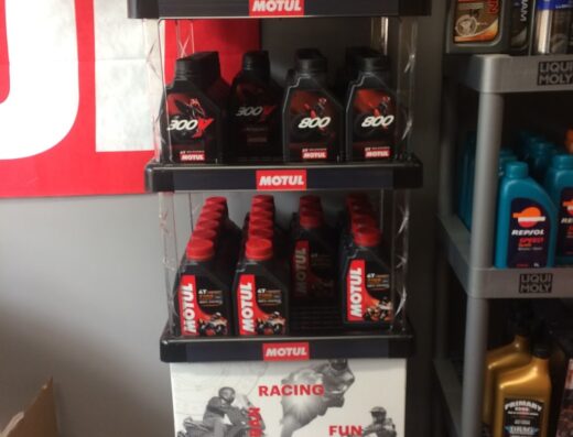 Scaffale espositore con prodotti Motul per moto a Lecce: olio motore, lubrificanti catena e accessori per sport motoristici.