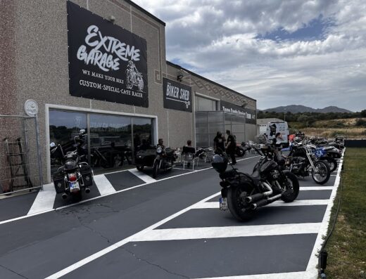 Esterno di Biker Shed, officina specializzata in moto custom e cafè racer. Harley Davidson parcheggiate, atmosfera rilassata e officina specializzata.