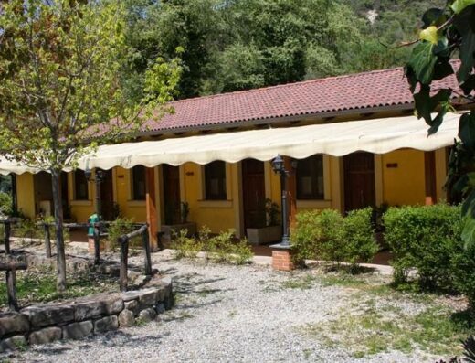 BioAgriturismo Tenuta Montenuovo: Facciata esterna delle camere con tendoni parasole, immersa nel verde, tipica architettura rurale italiana.