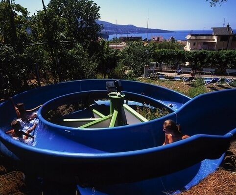 Scivolo d'acqua blu con persone che si divertono al Bleu Village Villaggio Turistico, un'attrazione acquatica per il tempo libero e il divertimento.