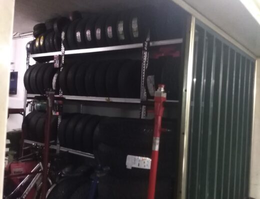 Scaffalatura metallica piena di pneumatici per moto da Bonometti Luigi, esperti in accessori e servizi per motociclisti.