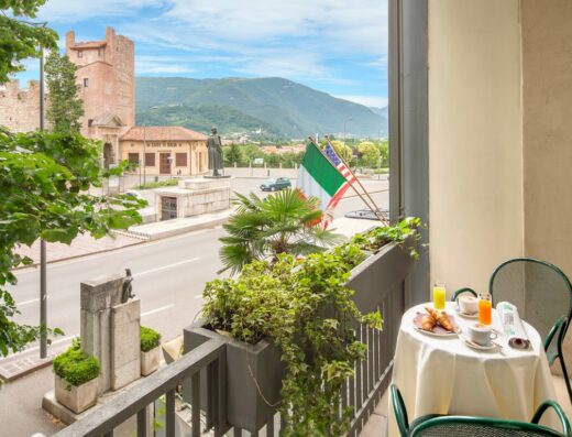 Vista dalla terrazza dell'Hotel Belvedere, con colazione servita all'aperto e scorcio panoramico sulla città di Bassano del Grappa.