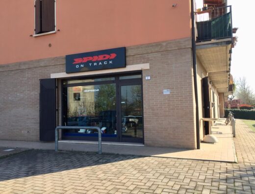 Negozio di abbigliamento e accessori moto BurnOut con insegna Spidi On Track, vetrina con caschi e abbigliamento tecnico per motociclisti.