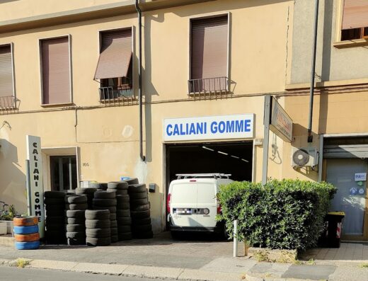 Caliani Gomme di Caliani Giorgio: negozio di pneumatici con furgone all'interno e pile di gomme all'esterno, servizio di vendita e montaggio pneumatici moto.