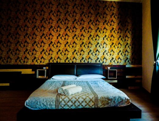 Camera matrimoniale del Camurria Sicilian B&B con letto rifatto, asciugamani arrotolati e decorazioni murali originali.