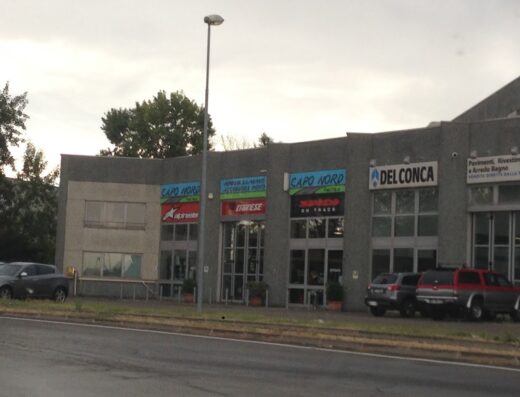 Caponord Faenza store front featuring motorcycle gear and accessories, including Dainese and Alpinestars brands. The building also hosts Del Conca.