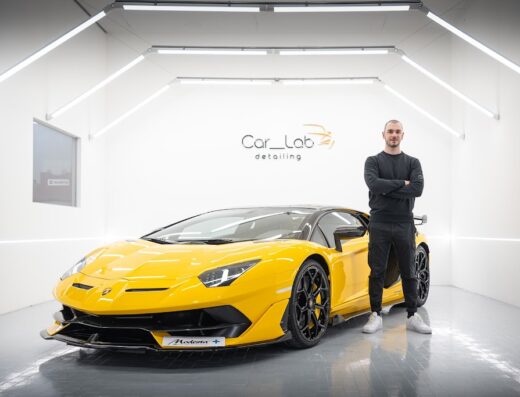 Auto gialla di lusso presso Car Lab Detailing, con il proprietario in posa. Servizi professionali di cura auto per un'estetica impeccabile.