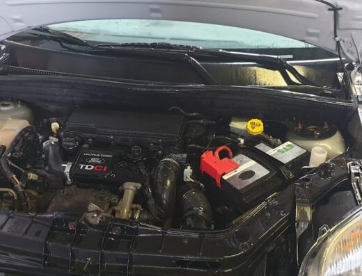 Motore di un'auto Ford Duratorq TDCI con cofano aperto, componenti meccaniche in primo piano, manutenzione auto, dettaglio motore, lavaggio auto.