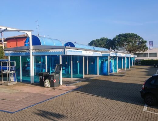 Autolavaggio self-service in Italia con box blu per il lavaggio di auto e moto, tipico servizio per motociclisti in viaggio.