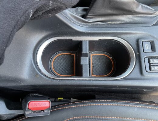 Interno auto con portabicchieri puliti e dettagli arancioni, ideale per servizio auto lavaggio sicuro e professionale.