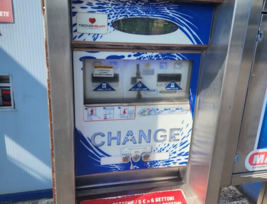 Macchina cambia soldi self-service per autolavaggio, utile per i motociclisti che vogliono pulire la propria moto in viaggio, con indicazioni sui prezzi dei gettoni