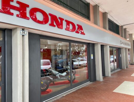 La facciata della Casa della Moto di Binello Alessandro, concessionario Honda, con una moto esposta in vetrina.