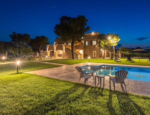 Casale Ferrantino di sera con piscina illuminata, sedie da esterno e prato verde curato, ideale per vacanze e relax