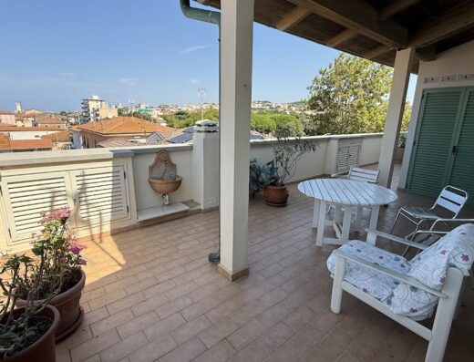 Vista panoramica dalla terrazza dell'hotel Casamare, con arredi da esterno, piante e scorcio sulla città.