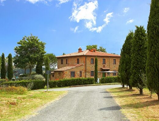Castellare di Tonda in Toscana: una villa storica con vialetto alberato, cipressi e cielo azzurro, ideale per vacanze e relax.
