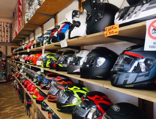 Scaffali pieni di caschi da moto di diverse marche e colori nel negozio Centaury's House, accessori per motociclisti e vendita di caschi.