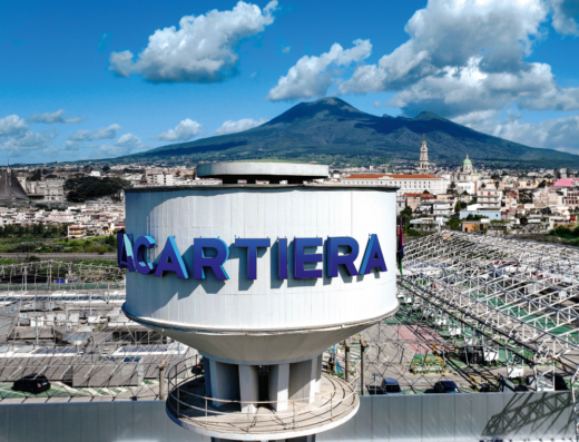 Centro Commerciale La Cartiera con il Vesuvio sullo sfondo, Pompei, Italia. Vista aerea del parcheggio del centro commerciale.