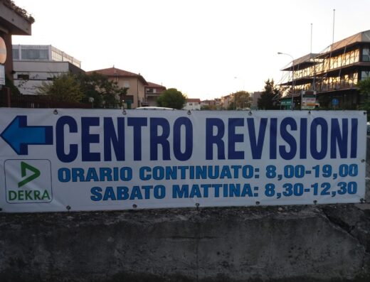 Insegna del Centro Revisioni Thesi con orari di apertura per revisioni moto e auto, servizio Dekra.