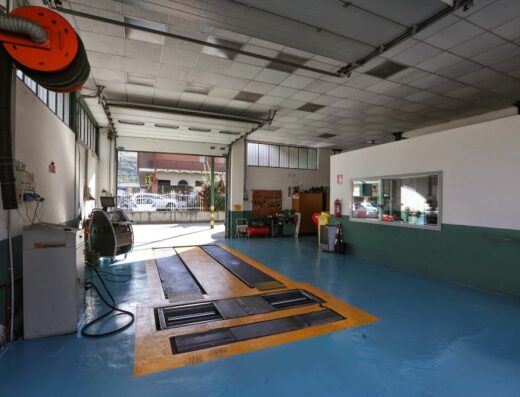 Internal view of Centro Valdostano Revisioni, a motorcycle service center with vehicle inspection pit and equipment, located in Aosta Valley