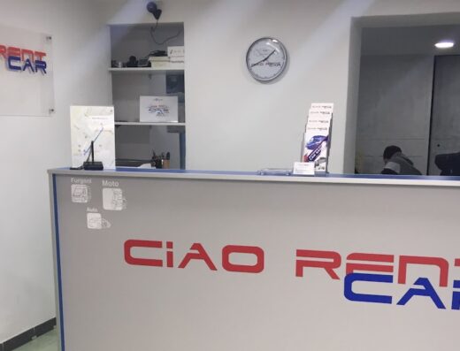 Interno dell'ufficio Ciao Rent Car a Milano Centrale, con banco reception che offre servizi di noleggio auto, moto e furgoni.
