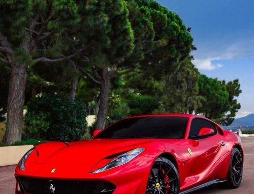 Cagliari autonoleggio: Ferrari rossa lussuosa parcheggiata all'aperto, ideale per un viaggio esclusivo in Sardegna. Noleggio auto sportive e di prestigio.