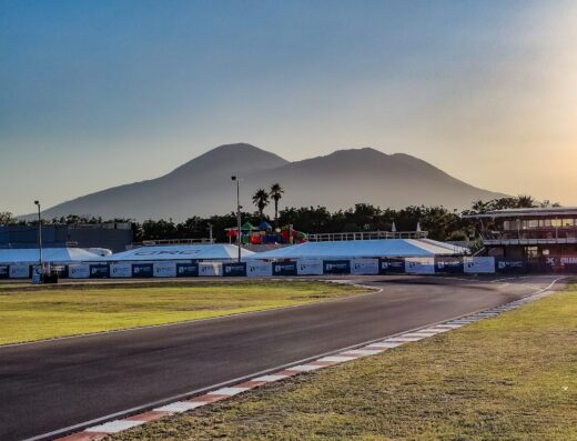 Circuito Internazionale Napoli: Panorama del circuito con tende, tribune e il Vesuvio sullo sfondo. Ideale per appassionati di motociclismo e competizioni.