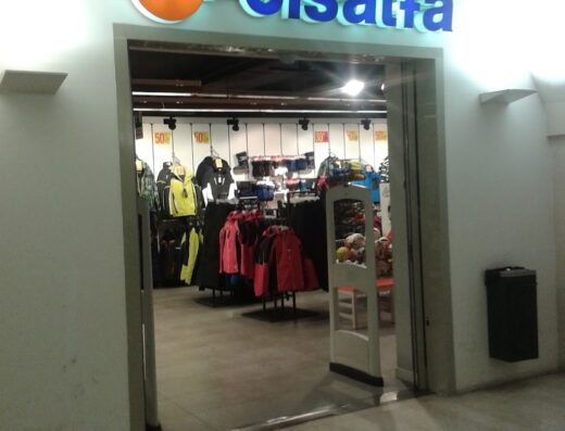 Ingresso del negozio Cisalfa Sport a Vicenza, con abbigliamento sportivo esposto e insegna luminosa del marchio.