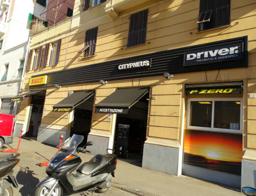 CITY PNEUS S.R.L.: negozio di pneumatici e assistenza per moto con scooter parcheggiati di fronte, marchi Pirelli e Driver.