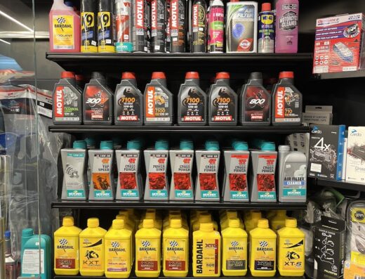 Scaffale fornito di oli motore, lubrificanti e prodotti per la manutenzione moto presso Convertino Moto Racing, concessionaria specializzata in accessori e ricambi per motocicli