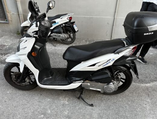 Noleggio scooter Cooltra a Castellammare di Stabia: scooter bianco con bauletto SH33 per il trasporto bagagli, ideale per esplorare la città.