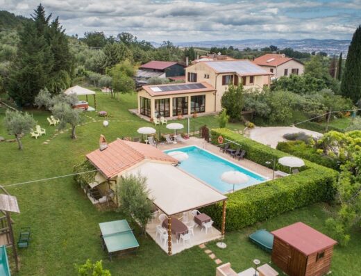 Vista aerea della casa di campagna Nonna Rana con piscina, area giochi per bambini, tavolo da ping pong, area salotto all'aperto e giardino curato.