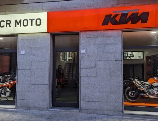 Foto della concessionaria ufficiale KTM, CR Moto, con vetrine che espongono modelli di moto KTM e accessori per motociclisti.