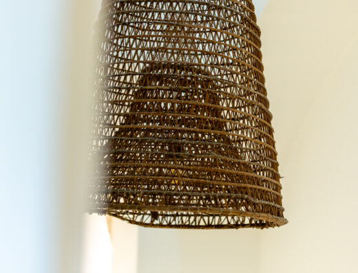 Lampada artigianale in vimini marrone appesa al soffitto del Crobi Museum and Suites, illuminazione interna di design.