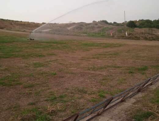 Cross Park Gino Meli: un irrigatore automatico in azione, mantenendo verde il prato del parco, essenziale per le attività motociclistiche e per il comfort dei visitatori.