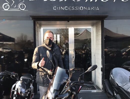 Uomo davanti alla concessionaria D.C.R. Moto con moto Benelli e Honda, accessori e vendita di motocicli a Roma