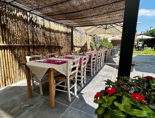 Tavoli apparecchiati all'aperto presso Da Nati Locanda e B&B, pronti per accogliere ospiti in un ambiente accogliente e curato.