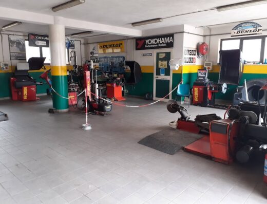 Interno dell'officina di Dalessandri Michele, specializzata in servizi per moto e pneumatici, con attrezzature Corghi e marchi Yokohama e Dunlop.