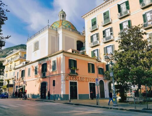 De Cesare Viaggi: vista esterna dell'agenzia viaggi con insegna ben visibile, architettura tipica italiana e persone di passaggio.