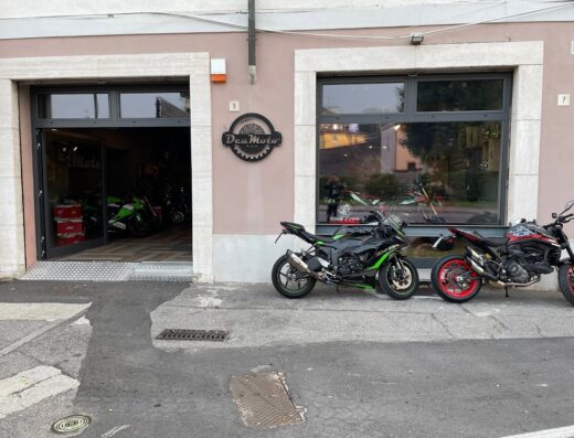 Dea Moto Cremona: vista esterna del negozio con motociclette esposte, vetrina, insegna e ingresso aperto. Servizi e vendita moto.