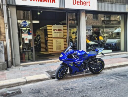 Concessionaria ufficiale Yamaha Debert Jr: primo piano di una moto Yamaha blu da corsa esposta di fronte all'entrata del negozio.