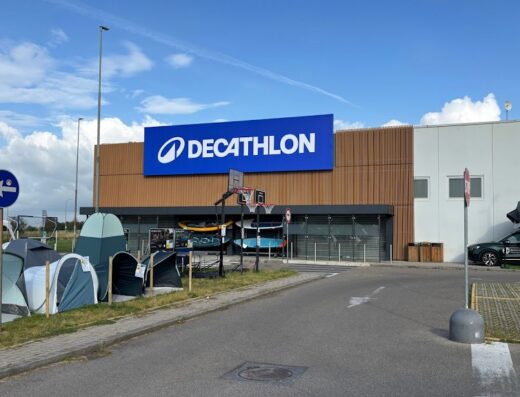 Decathlon Cascina: esposizione esterna di tende da campeggio e accessori per l'outdoor, con auto attrezzata per il campeggio sul tetto.