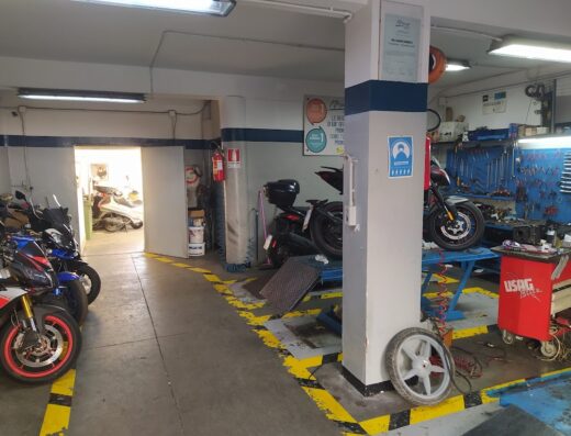 Interno dell'officina di Del Gaone Roberto, con moto in riparazione, attrezzature, e moto parcheggiate. Servizi di riparazione e manutenzione moto.
